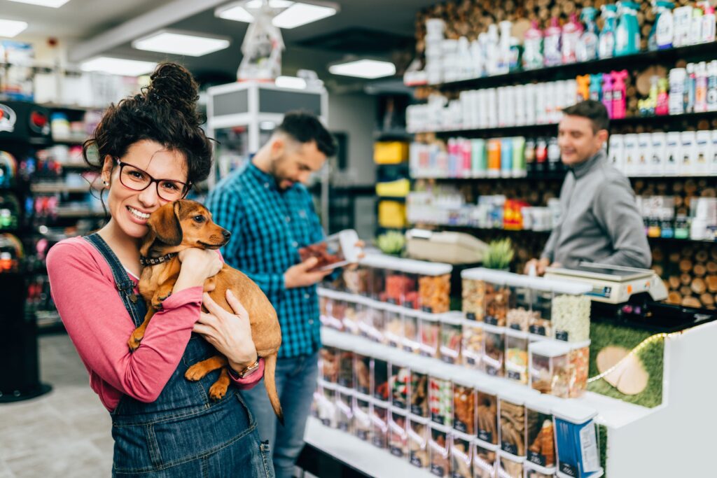 Tutor segurando cão no pet shop