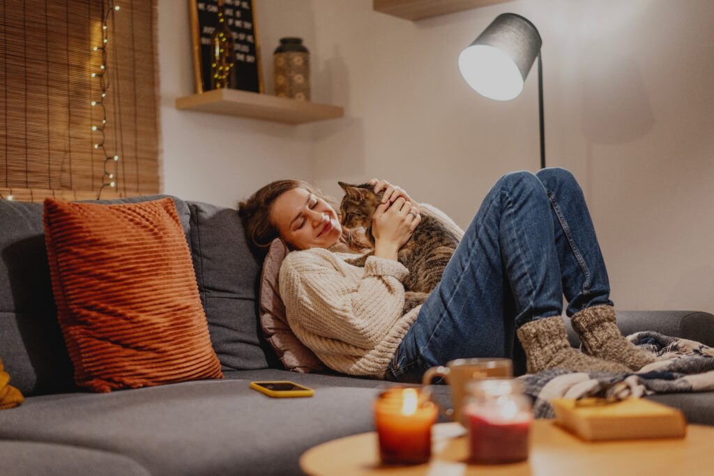 Tutora deitada no sofá com seu gato