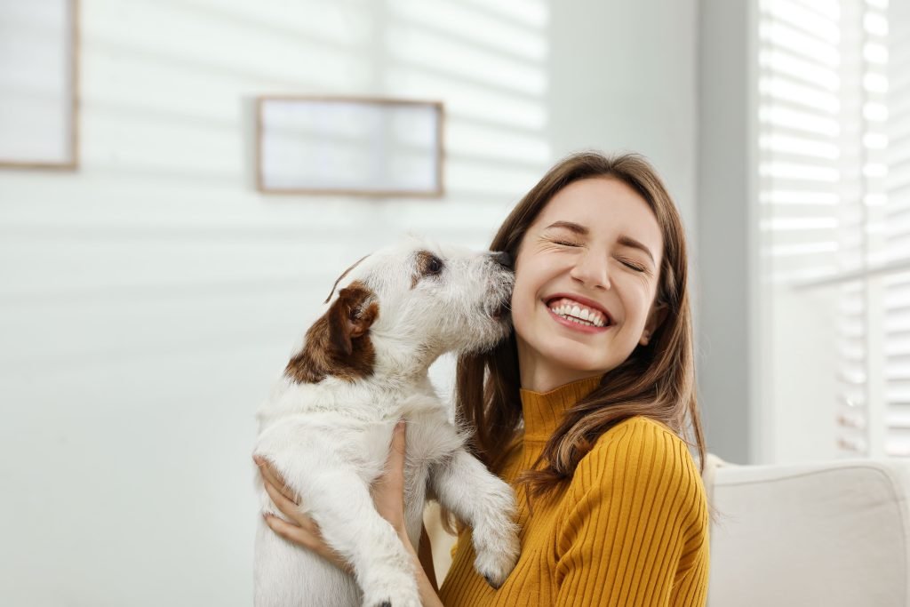 Cão beijando tutora na bochecha