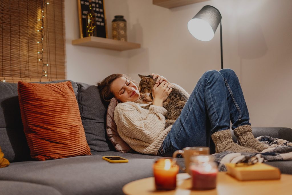 Gato e mulher deitados no sofá