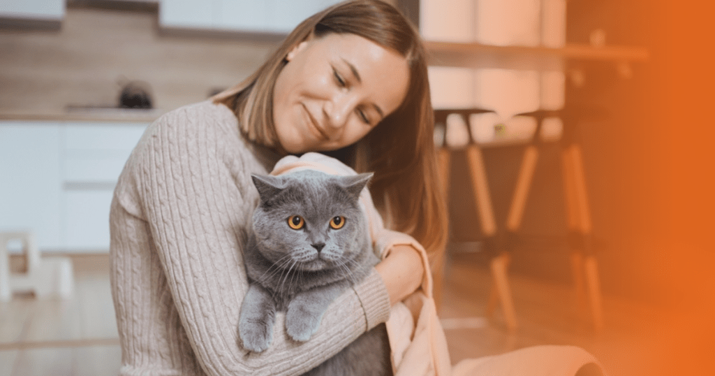 Tutora abraçando gato cinza
