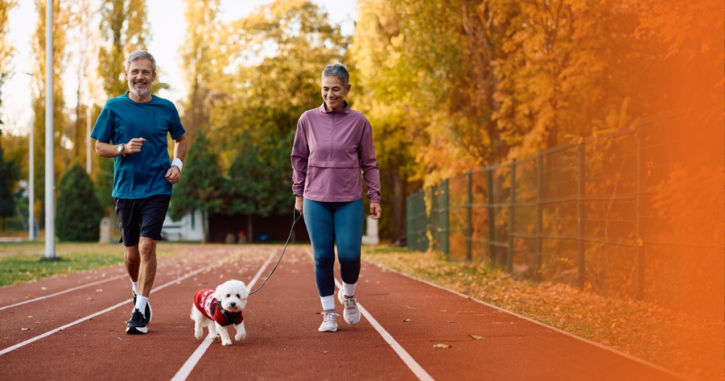 Dois tutores praticando esporte com cachorro
