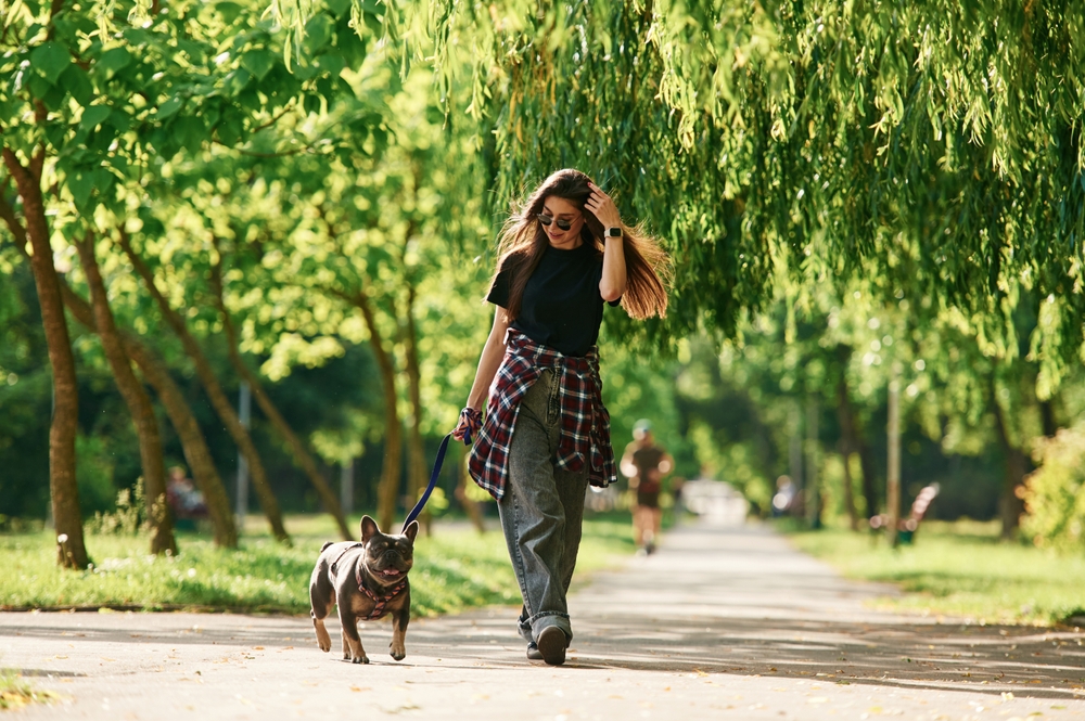 Tutora caminhando com seu cachorro no parque