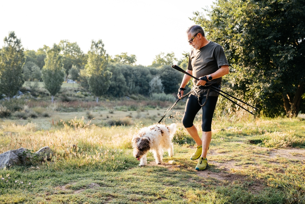 Homem com seu cão no campo se preparando para se exercitar