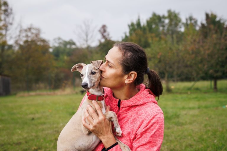Tutora abraçando e beijando seu cão